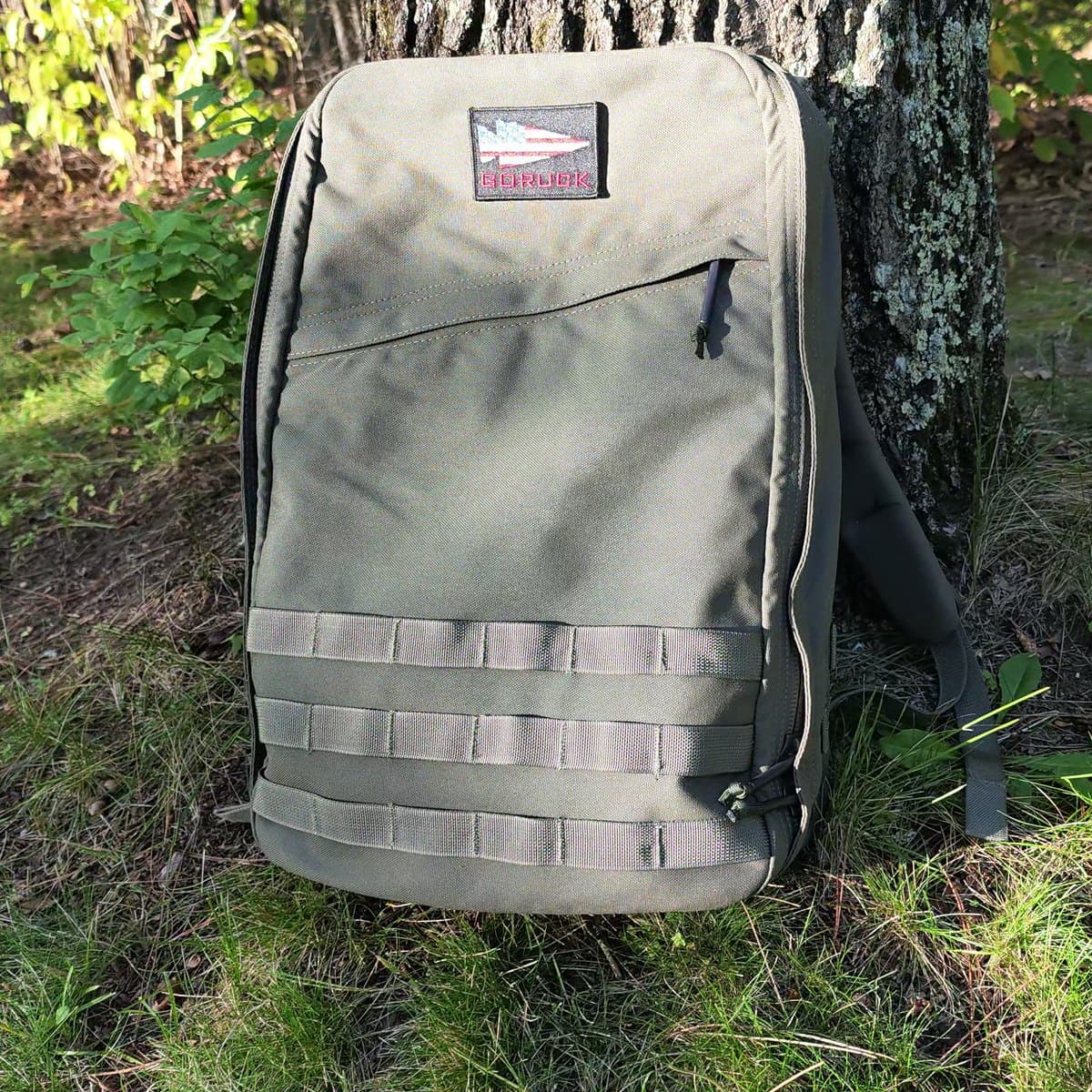My green 26L GORUCK GR1 standing against a tree