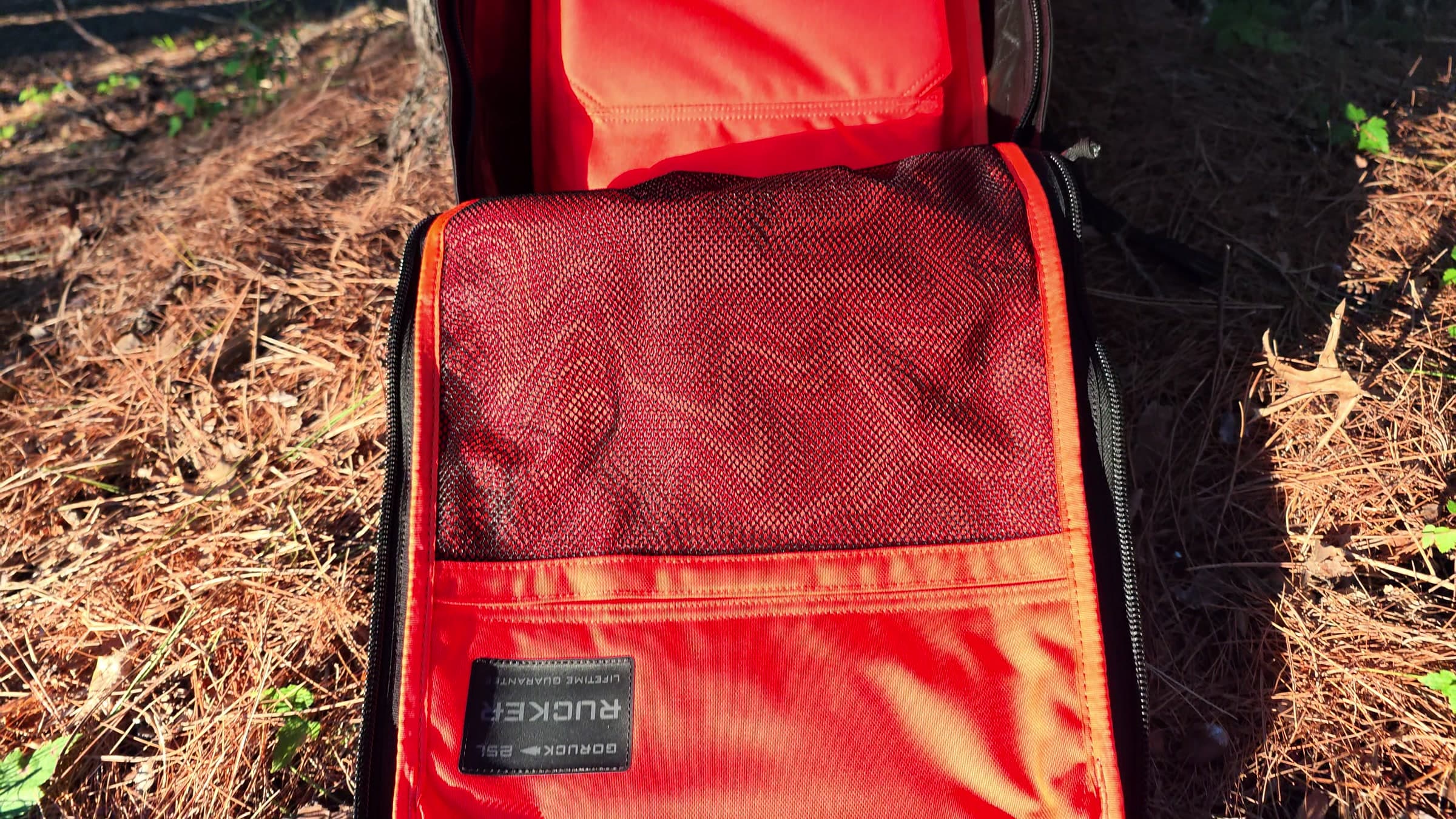 The Rucker 5.0 opened flat, showing the orange-lined interior and mesh pocket