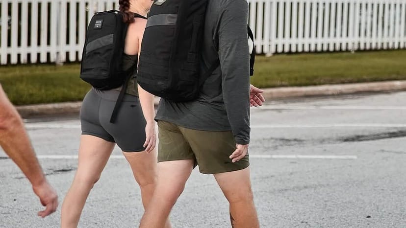 Una mochila GORUCK abierta sobre tablas de madera desgastada con una placa de carga al lado - la configuración estándar
